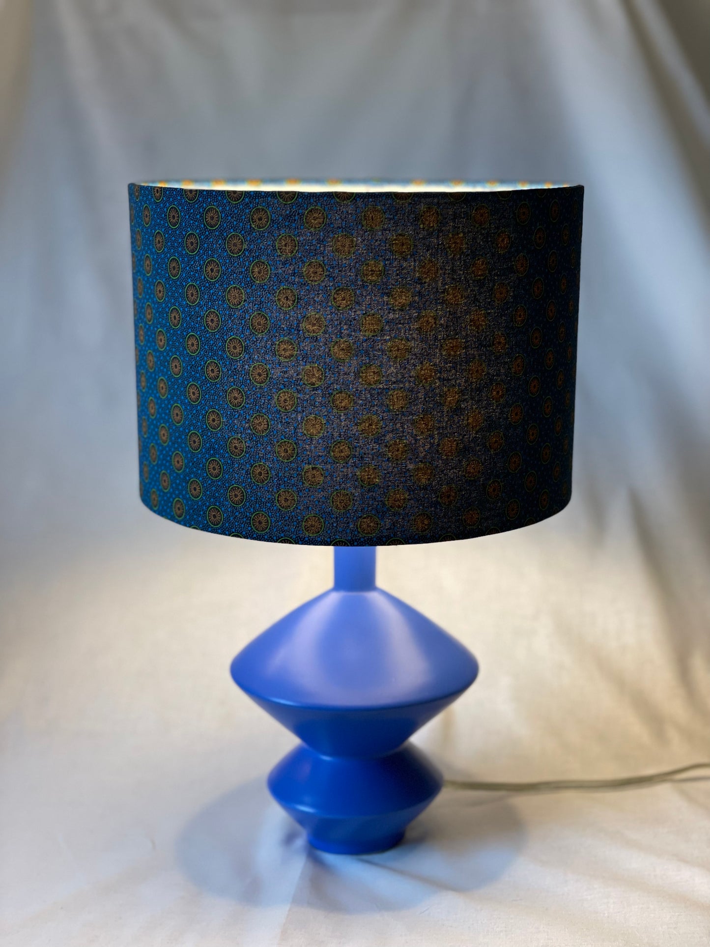 10 inch Drum Lampshade. Dynamic South African Shwe Shwe Print- Navy Blue with Orange and Green Medallion and Tiny Blue Dots.