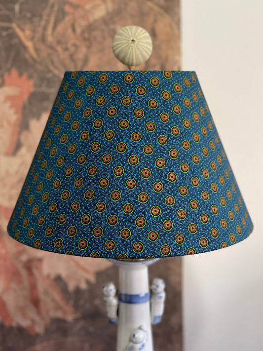 Small Conical Lampshade. Dynamic South African Shwe Shwe Print- Navy Blue with Orange and Green Medallion and Tiny Blue Dots.