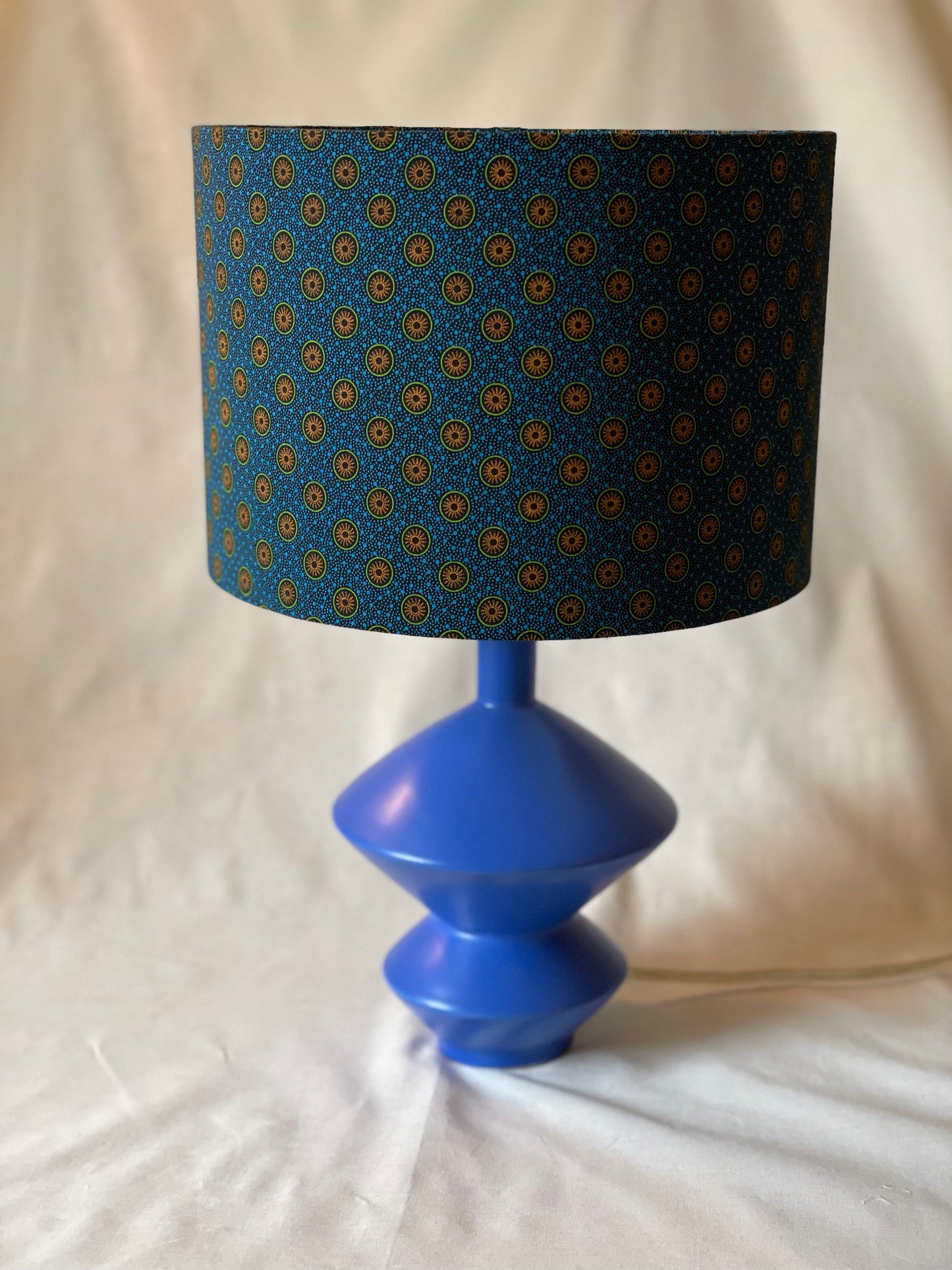 10 inch Drum Lampshade. Dynamic South African Shwe Shwe Print- Navy Blue with Orange and Green Medallion and Tiny Blue Dots.